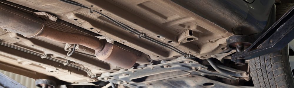 bottow view of car lifted on auto hoist at service station